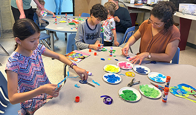 families and teachers working on craft projects around classroom tables
